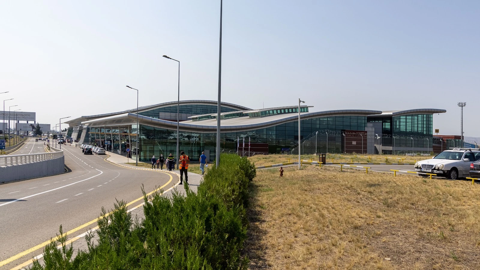 Car rental pickup zone at Tbilisi Airport with vehicles ready for collection